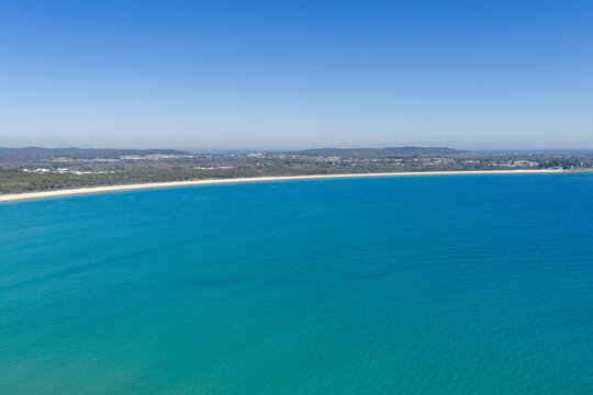 An aerial view across the expansive sandy shoreline of Front Beach at Trial Bay, South West Rocks, New South Wales, Australia.