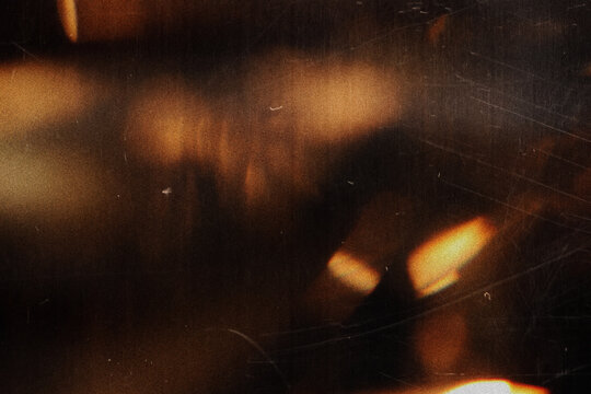 Moody black background featuring warm golden light effects, blurred highlights, lens flare and analog film grain, perfect for cinematic visuals, luxury branding and digital design.