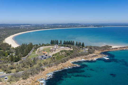 Aerial view of Laggers Point featuring the historic Trial Bay Gaol, rugged coastline, turquoise ocean and forested mountains near South West Rocks, New South Wales, Australia.