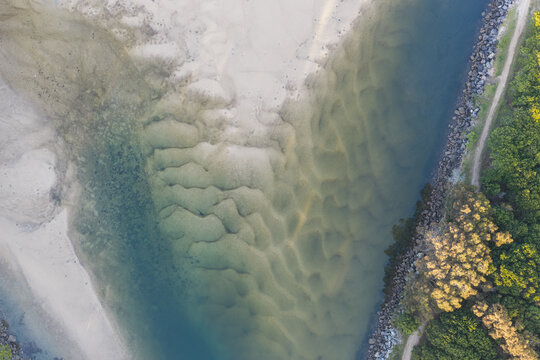 Downward aerial view of natural sand patterns visible beneath the clear tidal water of Back Creek at South West Rocks, New South Wales, Australia.