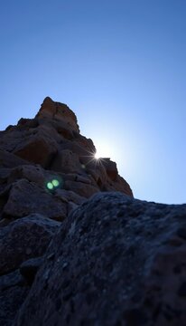 Low-angle shot of rocky outcropping at sunrise, dramatic, sun