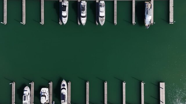 Top view from drone of sailboats and various speed boats in dock. Aerial view of luxure yachts and motorboats moored in a port with clear blue water in summer. Vilamoura, Algarve, Portugal