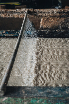 Water spraying onto cassava mash pulp on a moving conveyor screen during tapioca starch extraction processing at a factory in Central Java Indonesia