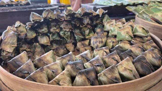 Traditional Terengganu sata fish snacks grill over hot charcoal embers. Wrapped in banana leaves, the seasoned fish paste cooks slowly to perfection.