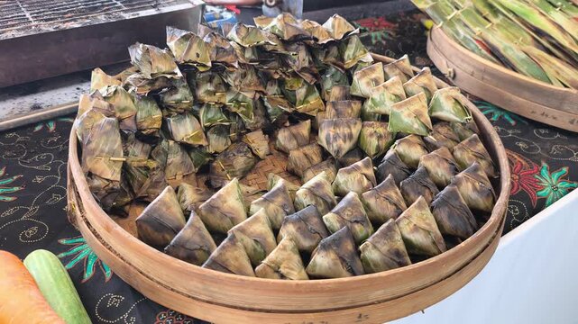 Traditional Terengganu sata fish snacks grill over hot charcoal embers. Wrapped in banana leaves, the seasoned fish paste cooks slowly to perfection.
