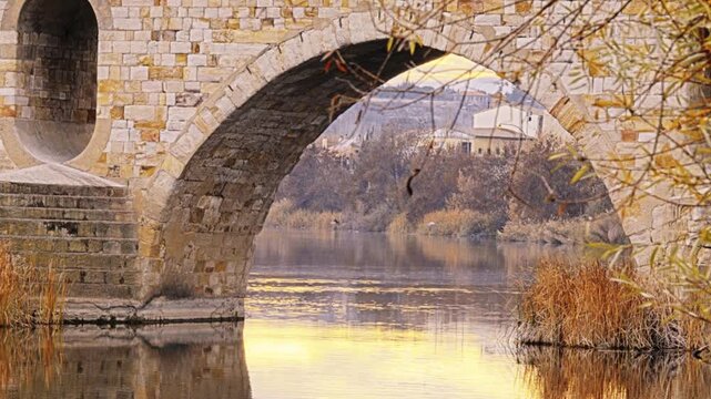 Masonry Pointed arch Stone bridge (Puente de Piedra) across the river Duero in Zamora, Castile-Leon, Spain. Reflection in the water. Autumn nature.
