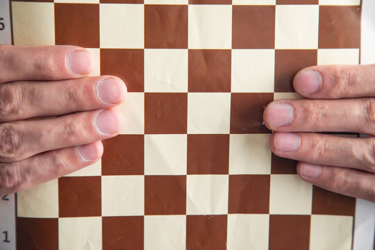 Caucasian man showing chess board.