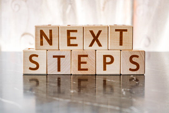 motivational word Next steps, from letters on wooden cubes