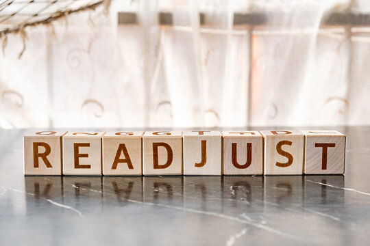 motivational word Readjust, from letters on wooden cubes
