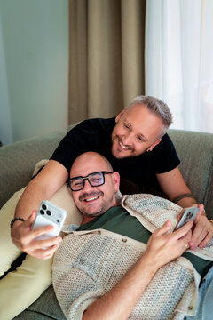 Homosexual couple relaxing on sofa at home