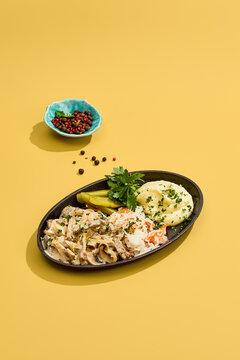 Beef stroganoff with creamy mushroom sauce, smooth potato puree and crisp cabbage on a yellow background for cafe menu