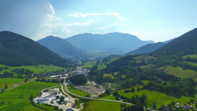 Scenic view of mountains and valleys with a town under bright blue sky. Mountains surround a valley with a small town and green fields under a clear sky.