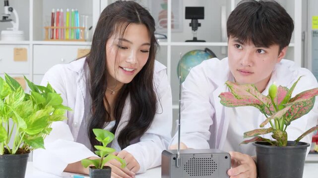 Teenage Students in Lab Coats Conducting Plant Science Experiment with Radio