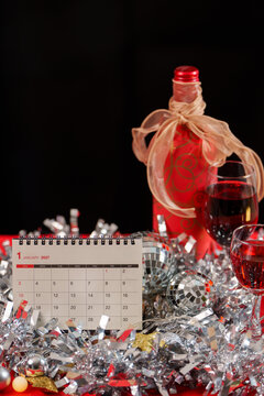 January 2027 calendar with wine glass and tinsel for New Year celebration