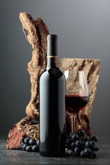 Obraz premium Red wine with stone, dried snags, and blue grapes.