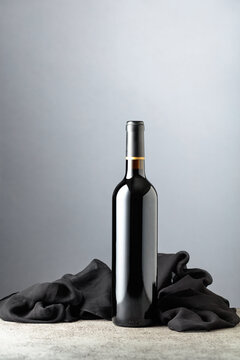 Bottle of red wine on a grey background.
