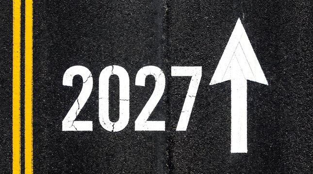 Road marking with a large white arrow pointing upwards and the number 2027 on asphalt