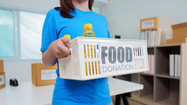 Cropped person holding plastic crate for food donation in charity office