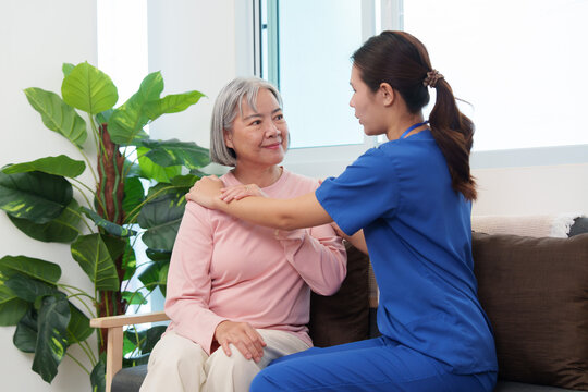 Asian nurse comforting senior woman with gentle touch at home for caregiving