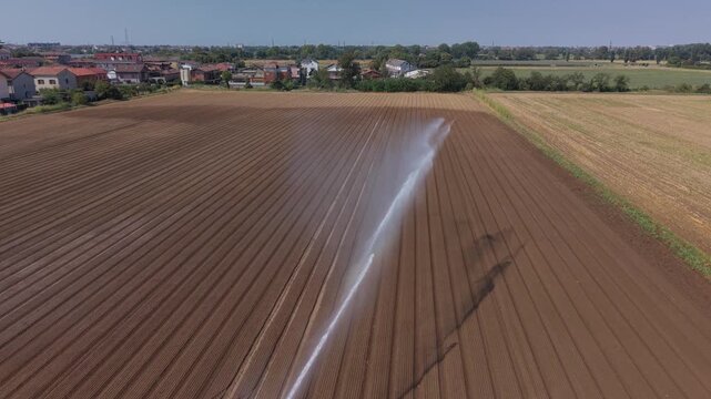 Agricultural Irrigation Sprinkler Watering Vegetable Crops in Northern Italy. Drone Aerial View 