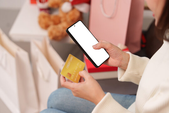 Person holding smartphone with blank screen and credit card for online shopping