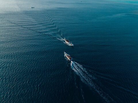 Aerial view of two traditional wooden boats navigating the deep blue waters of the Java Sea near Karimunjawa, Jawa Tengah, Indonesia.