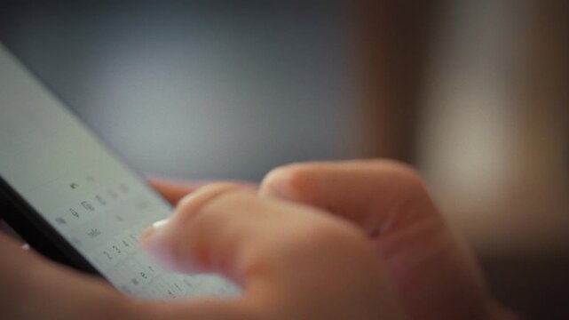A man types a note on his smartphone's touch keyboard, fingers gliding confidently across the screen. The device functions as a digital notepad, instantly saving thoughts within the sleek application