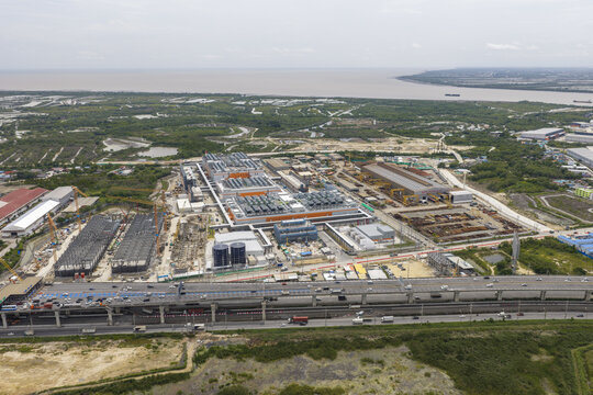 Aerial view of a large hyperscale data center complex under development with industrial buildings and construction infrastructure situated near a highway in Bangkok, Bangkok, Thailand.