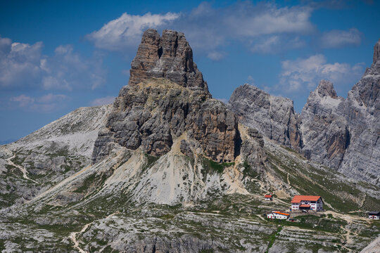 Majestic scenery of rough mountain ridge near grassy hills Tre Cime, Dolomites Italy