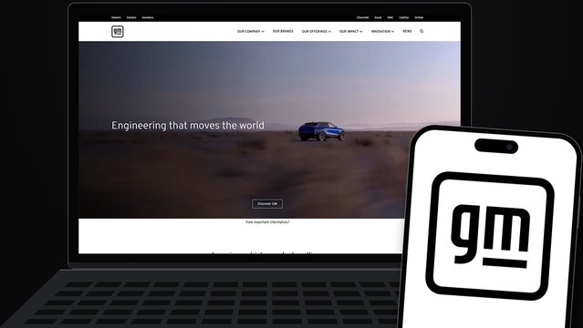 Izmir, Turkey - 30 Sep 2026: General Motors GM logo on a smartphone screen next to a laptop showing the GM website, the American automaker of cars and electric vehicles