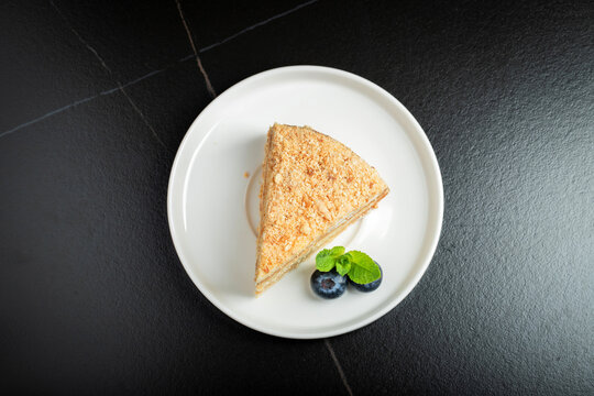 Medovik. Honey cake made from honey cakes with whipped sour cream, decorated with berries, pomegranate and flowers