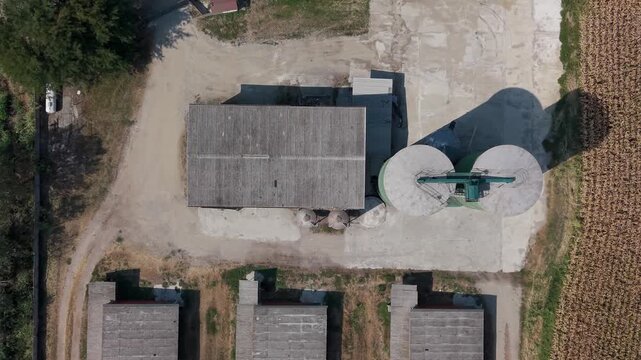 Aerial view of grain storage silos and agricultural warehouse buildings within a rural farming area.