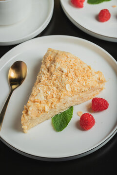 Sliced Napoleon cake on a white wooden table. Classic dessert