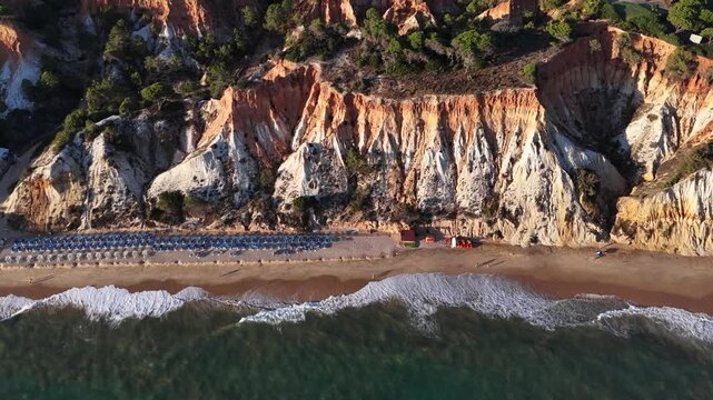 Falesia Beach, Algarve, Portugal. Golden mile beach with orange rocks, golden sand and turquoise sea. Aerial drone top view perspective. Sunset