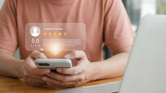 Person holding smartphone with holographic customer review rating of five stars and 5.0 score mobile phone