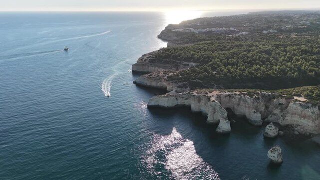 A sailboat is sailing off the coast of the Algarve, Portugal.