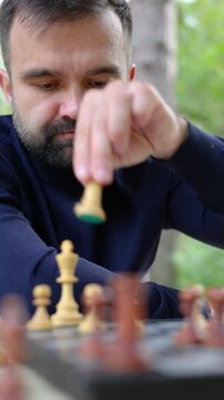 The man is gazing intently at the chessboard. He analyzes the situation on the board and performs a short castling move. He switches the rook and the king.