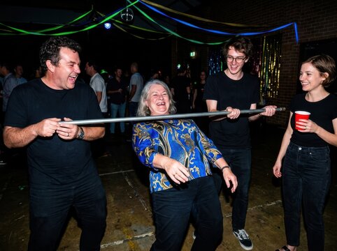 Playful party limbo game with friends laughing indoors at a celebration