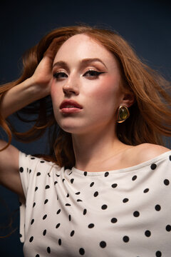 Woman in a polka dot top with windswept hair 