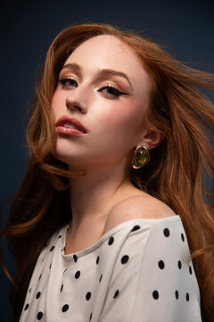 Woman in a polka dot top with windswept hair 