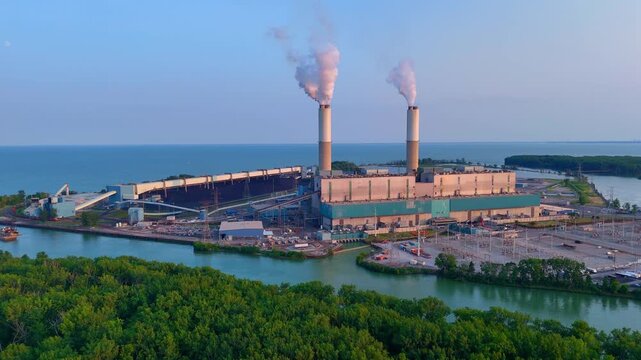 Monroe Coal Power Plant emitting smoke from its industrial chimneys over Lake Erie in Michigan, USA