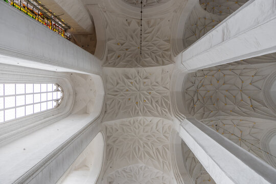 View of the intricate star-vaulted ceiling with white stone ribs and gold accents inside the historic St. Mary's Church in Gdansk, Pomeranian Voivodeship, Poland.