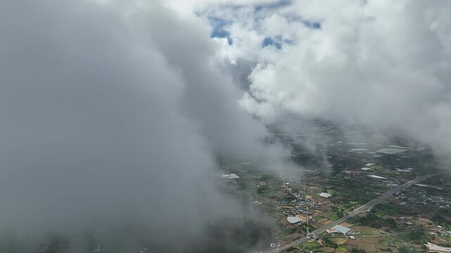 Airplane flying through clouds over rural landscape, South Korea
