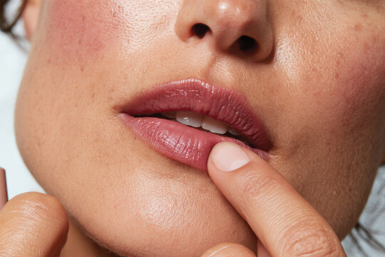 This close-up image showcases beautifully applied lip color on a model's lips, highlighting natural beauty and flawless skin, emphasizing allure and charm in makeup artistry.