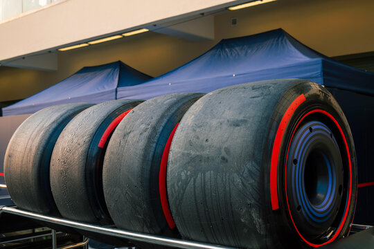 Close-up of Formula 1 racing tires stacked at a motorsport circuit, highlighting the specialized equipment used in professional Grand Prix racing.