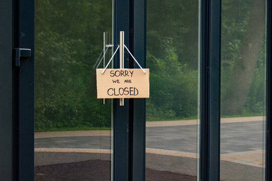 Sign SORRY WE ARE CLOSED on welcome door of small shop. Local business closure. Owners facing economic struggles and client loss