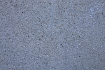 Fototapeta premium Close up view of a rough grey concrete wall surface with embedded small pebbles and grit texture