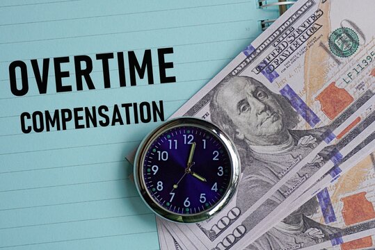 OVERTIME COMPENSATION. Employment concept. Additional pay for work exceeding standard hours for eligible employees. Background featuring lined notes, a clock and US Dollars