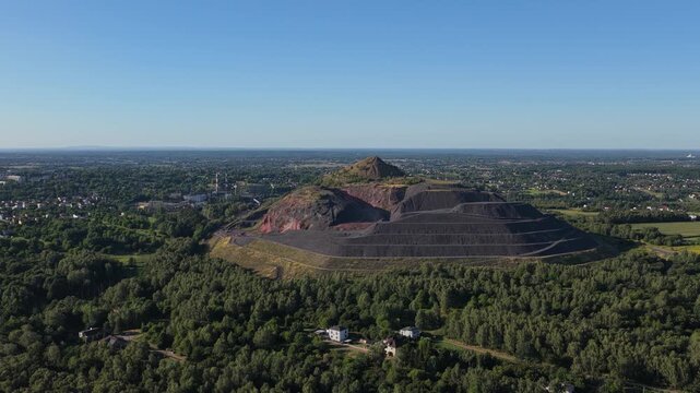 Drone flight over historic coal slag heaps and spoil tips in a green landscape