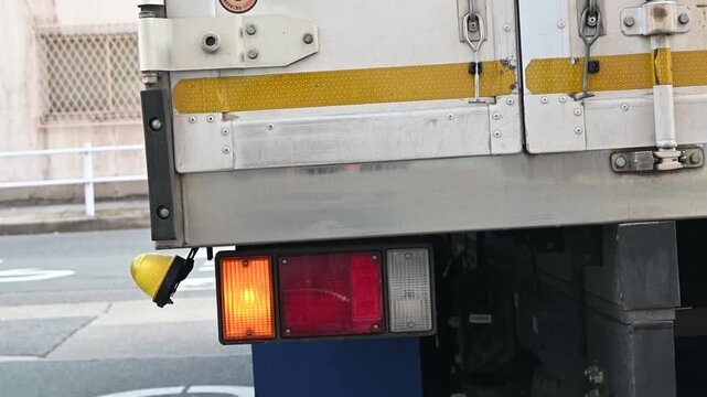 トラックの後部と点灯する方向指示器